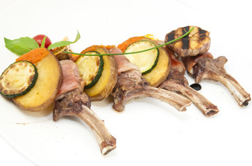 roasted veal ribs with vegetables on a white plate in a restaurant