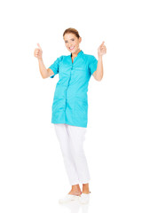 Smile young female doctor or nurse with thumbs up