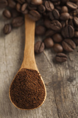 Ground coffee with coffee beans and cup of coffee with wooden background