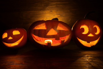 Funny Jack o lanterns Halloween pumpkins. Dark wooden background.