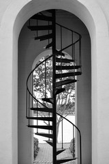 Black and white photo of tall metal stairs in a clock tower stairwell