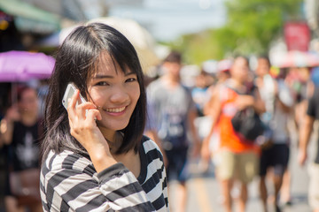 Fototapeta premium Cheerful woman talking on the phone in the street wearing a t-shirt