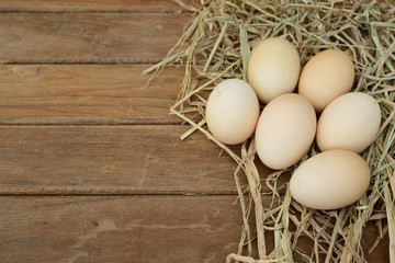 Egg in hay nest on wooden table background