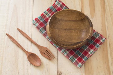 wood bowl and spoon with fork isolated on wood background