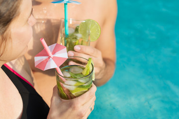 Pärchen trinkt Cocktail im Pool