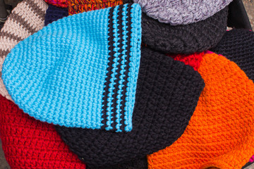 Collection of colorful caps for winter on stall at the bazaar