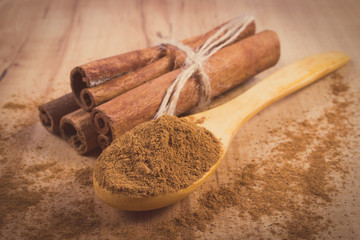 Powdery cinnamon and sticks on wooden table, seasoning for cooking