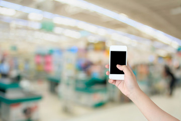 Hand use smartphone with Supermarket store background ,Cashier c
