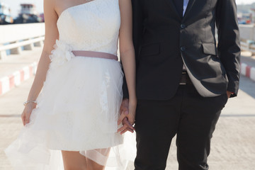 Fototapeta na wymiar Bride and groom holding hands