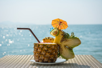 Fototapeta na wymiar Pineapple cocktail with beautiful sea in background