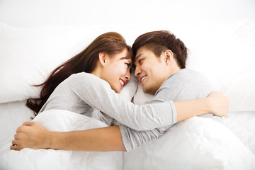 happy young lovely couple lying in a bed