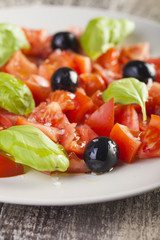 Salad dish with tomato, olives and basil