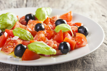Salad dish with tomato, olives and basil