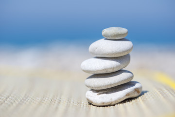 Fototapeta na wymiar Pebble stones on the straw mat, near the sea, on the beach.