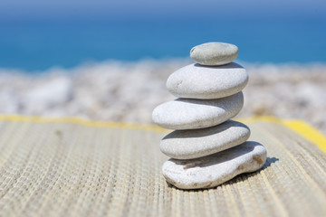 Fototapeta na wymiar Pebble stones on the straw mat, near the sea, on the beach.