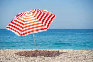 Fotobehang Striped beach umbrella on the beach.     © Evgeny Korshenkov