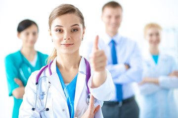 Young happy female doctor showing thumbs up