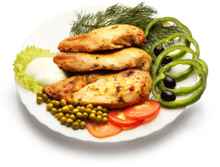 Chicken fillet decorated with pea, tomato, and paprika over white background