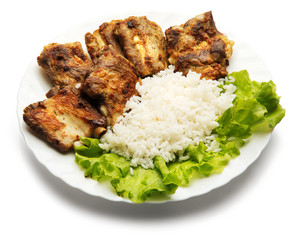 Pork ribs and rice decorated with salad over white background