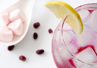 Glass of fresh drinking water with lemon, goji and candy hearts,