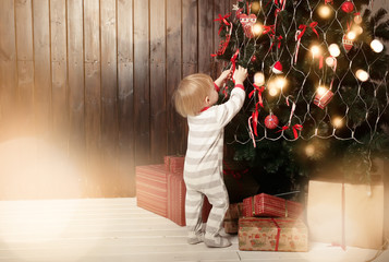 Back view of toddler boy decorating Christmas tree