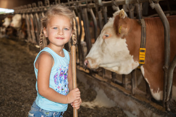 kleines Mädchen spielt im Kuhstall