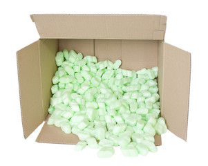 A brown, corrugated cardboard box with green packing foam pellets on a white background