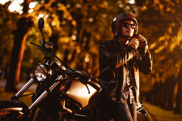 Fototapeta na wymiar Motorcyclist with a cafe-racer motorcycle outdoors