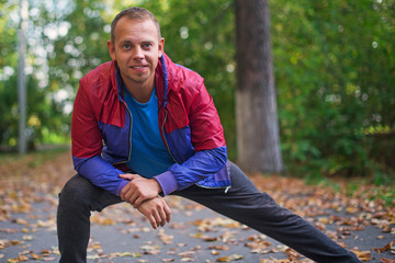 sport man stretching at the park autumn, doing exercises. Fitness concepts