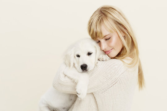 Young woman cuddling Labrador puppy