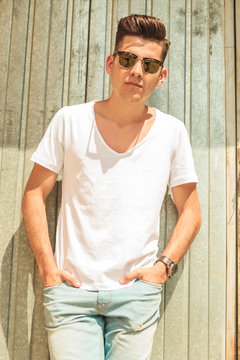relaxed man pose outside with both hands in pockets