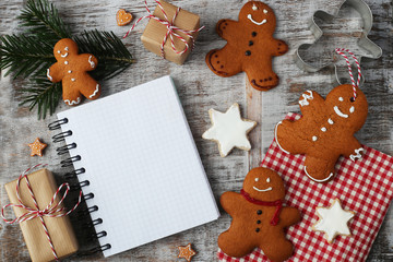 Ein leeres Ringbuch inmitten von Lebkuchenmännern und Geschenken