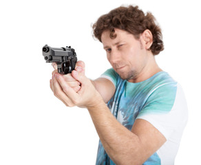 Caucasian adult man aiming with black gun in hands, isolated on white background, focus on weapon