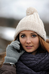 Junge Frau in Winterkleidung telefoniert mit Smartphone