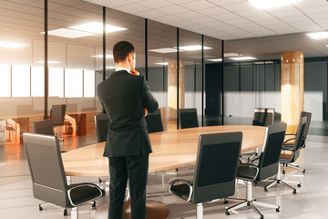 Businessman watching on round conference table with chairs in th