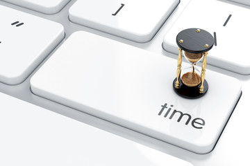 Time concept. Hourglass on the keyboard