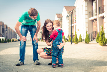 happy parents with little son at uptown street