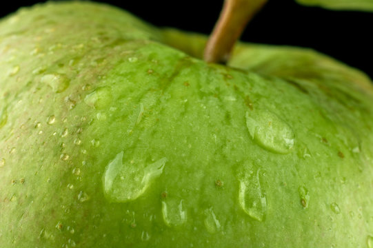 Macro Closeup Shot Of Drizzled Green Apple On Black