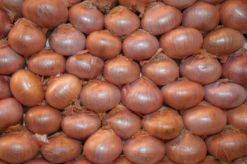 Fine stacked onions at market stall