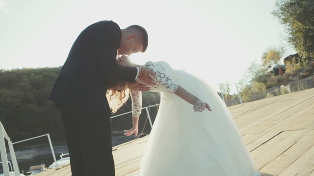 Wedding couple romantically kissing on the background of bright