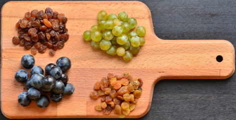 Various raisins and vine berries on chopping board
