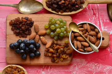 Various raisins, vine berries and almonds on chopping board