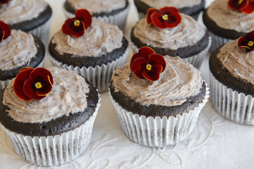 Homemade chocolate cupcakes with cookie and cream frosting and edible flower