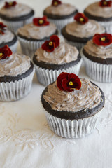 Homemade chocolate cupcakes with cookie and cream frosting and edible flower