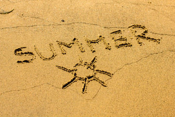 Sun and word Summer drawing on sandy beach background.