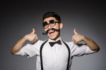 Naklejka premium Young caucasian man with false moustache against gray