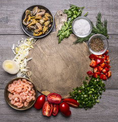 Cooking mussels shrimp tomatoes onions parsley dill garlic seasoning salt on a cutting board frame on wooden background top view close up space for text