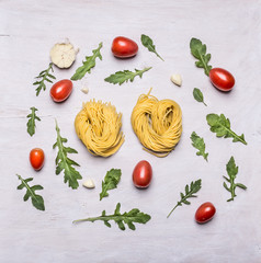Cooking Concept nest pasta Cherry tomatoes arugula and garlic on rustic wooden background top view
