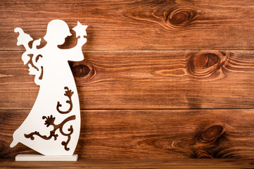 Christmas decorative white angel on the wooden background.