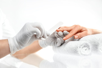 Piłowanie paznokci, manicure.
Zabieg pielęgnacyjny dłoni i paznokci, kobieta u kosmetyczki na zabiegu manicure. - obrazy, fototapety, plakaty